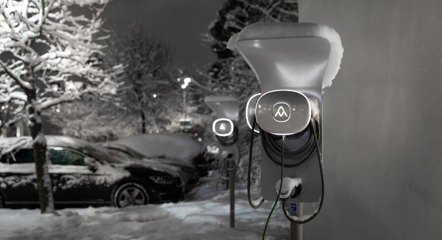 Elbilsladdare på rad på snötäckt parkering