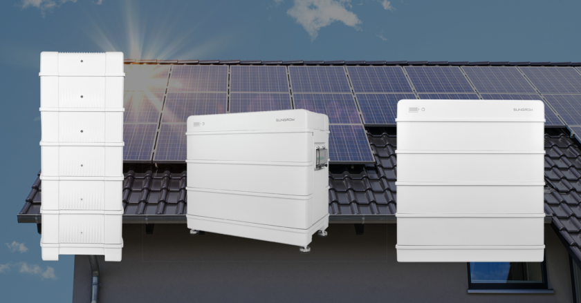 Solcellsbatterier i förgrunden och solcellsanläggning på hustak i bakgrunden