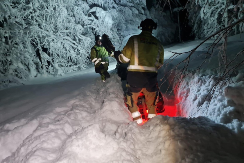 Två medarbetare på avdelning elnät som arbetar med att få loss snöskoter i djup snö och sträng kyla