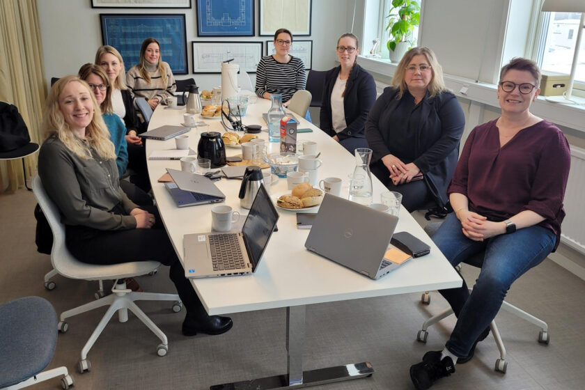 Medlemmar från Hållbarhetsnätverket sitter runt ett konferensbord