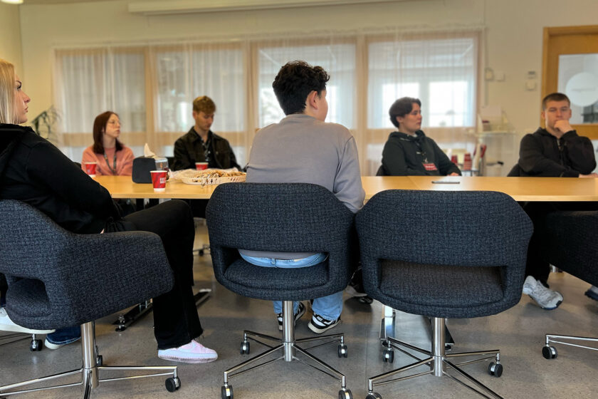 niondeklassare runt ett konferensbord lyssnar på föredrag
